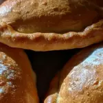 Kotitekoisia uunilihapiirakoita pellillä voilla voideltuna